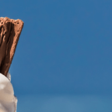 An ice cream with a flake with the beach in the background