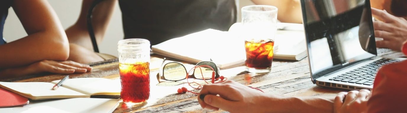 A group of people having a meeting around a table