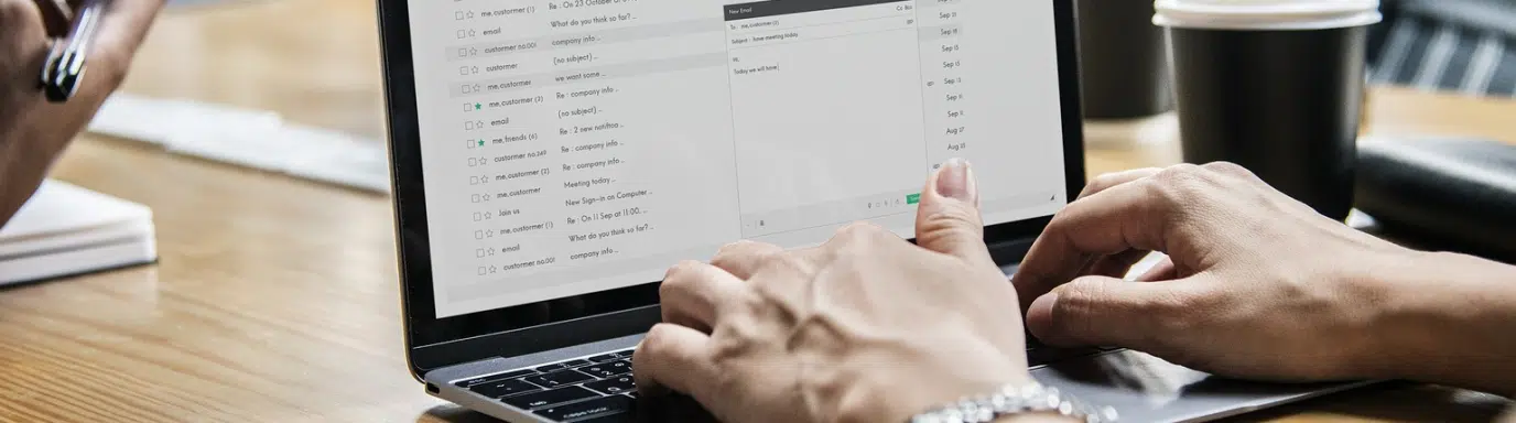 A woman typing notes on her laptop at her desk