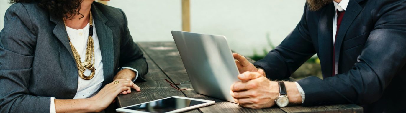 A man and woman having a meeting at an outside table