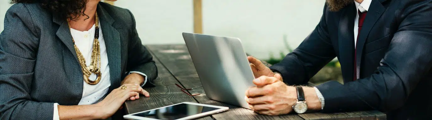 A man and woman having a meeting at an outside table