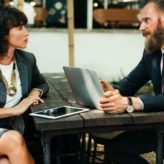 A man and woman having a meeting at an outside table