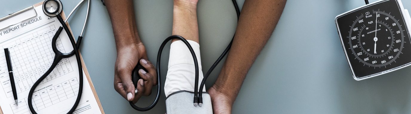 A Doctor taking a patients blood pressure