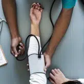 A Doctor taking a patients blood pressure