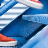 A person in red trainers walking up the stairs