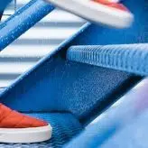 A person in red trainers walking up the stairs