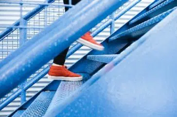 A person in red trainers walking up the stairs