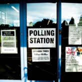 A window with a polling station sign