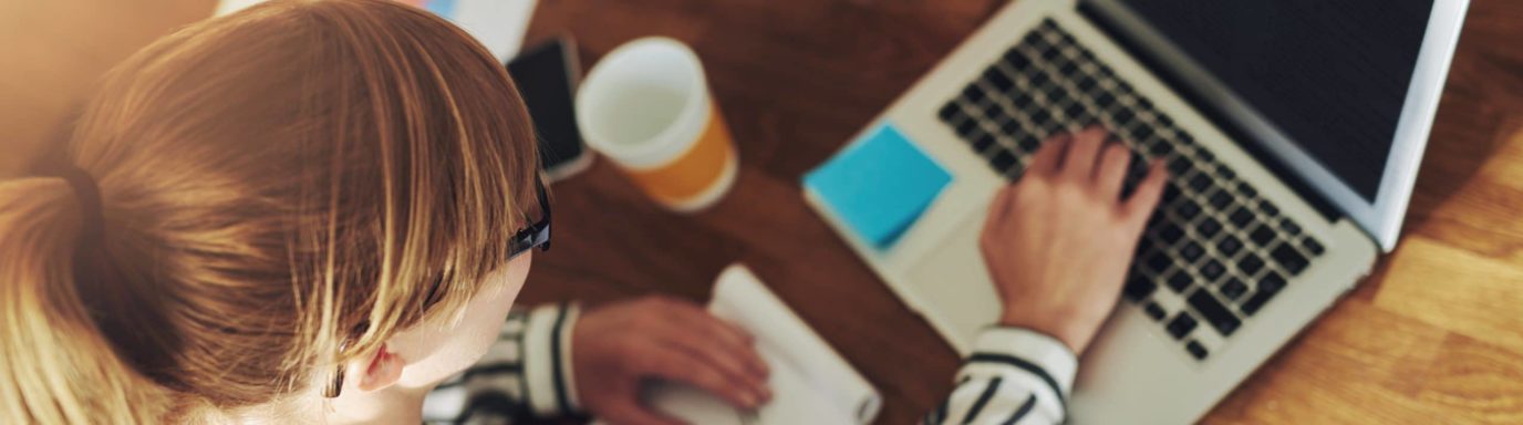 Woman sat at her desk doing a training course on her laptop