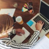 Woman sat at her desk doing a training course on her laptop