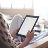 An employee reading work notes on her ipad in her living room