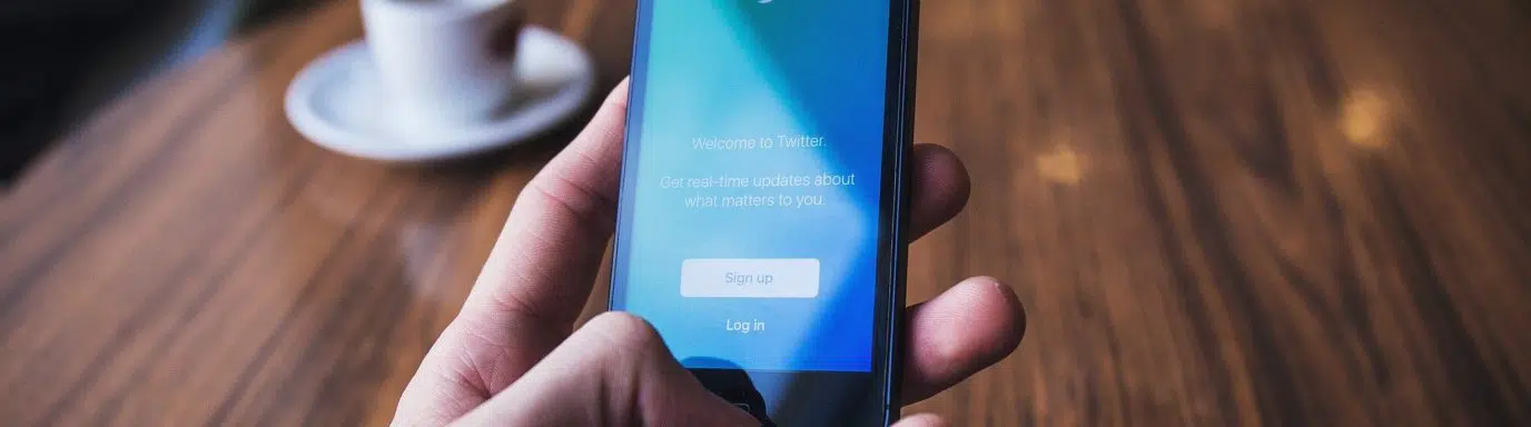 Person holding an iphone looking at thr Twitter app sign in page