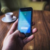 Person holding an iphone looking at thr Twitter app sign in page