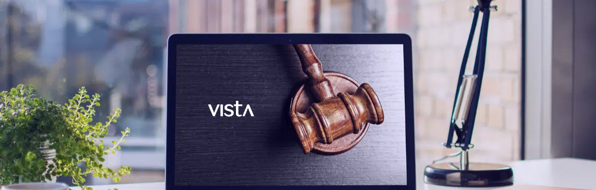 A laptop on an employees desk with a Judges gavel image on the screen