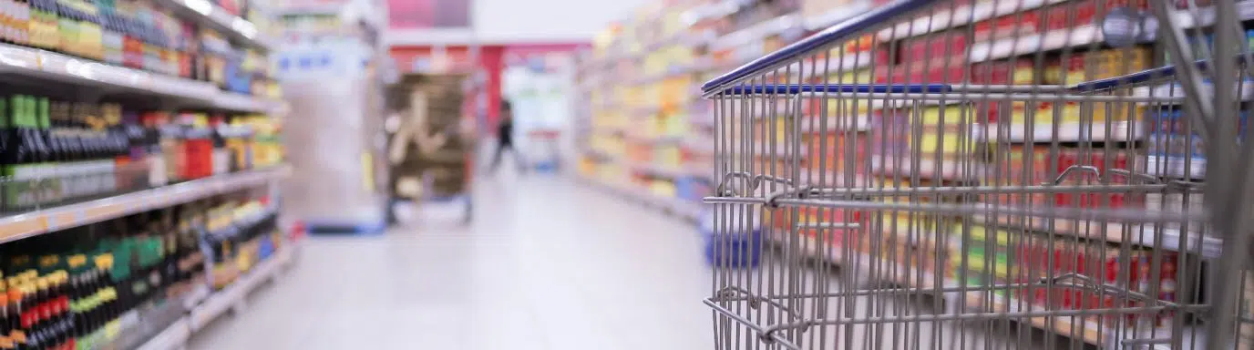 An empty shopping trolley in an empty supermarket isle