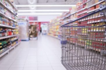 An empty shopping trolley in an empty supermarket isle