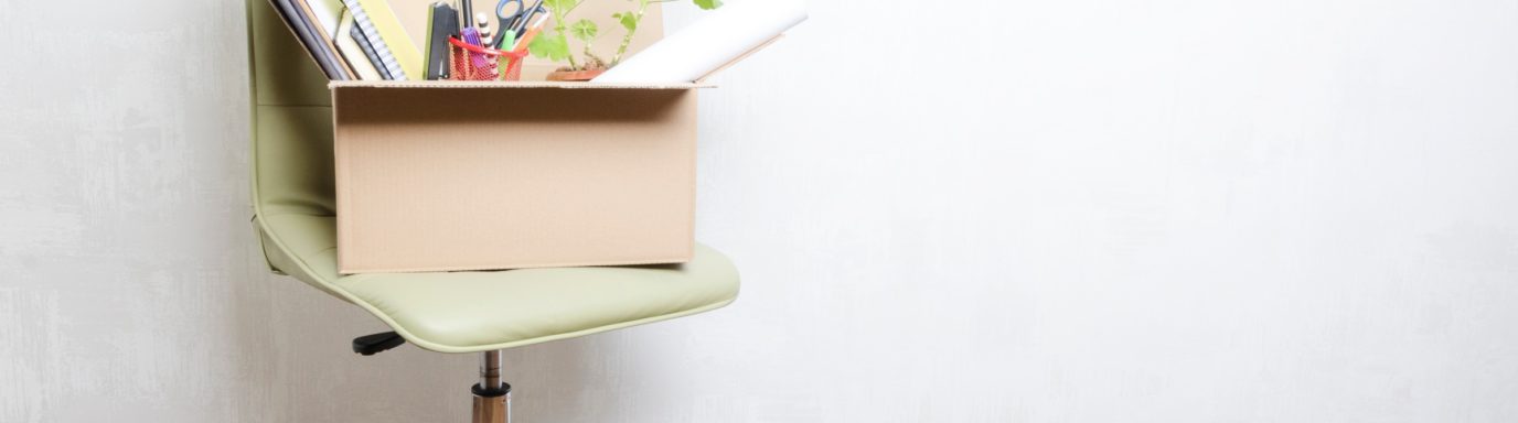 A chair with a box full of office equipment on top of it