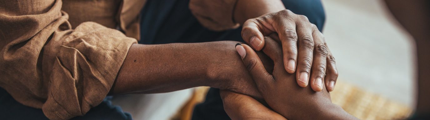 An image of a male carer holding hands with a lady