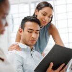 Workplace harassment, sexual abuse and unprofessional behavior from flirting business woman touching a coworker in an office. Awkward man feeling uncomfortable with unethical relationship and affair