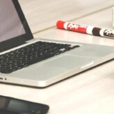 Man sat with laptop around a table with 4 people