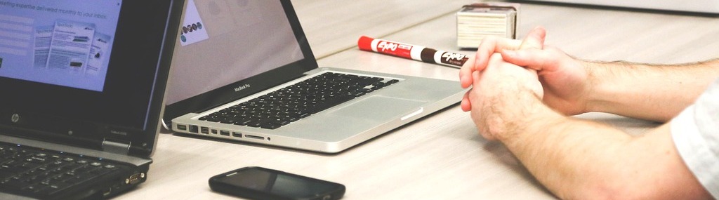 Man sat with laptop around a table with 4 people